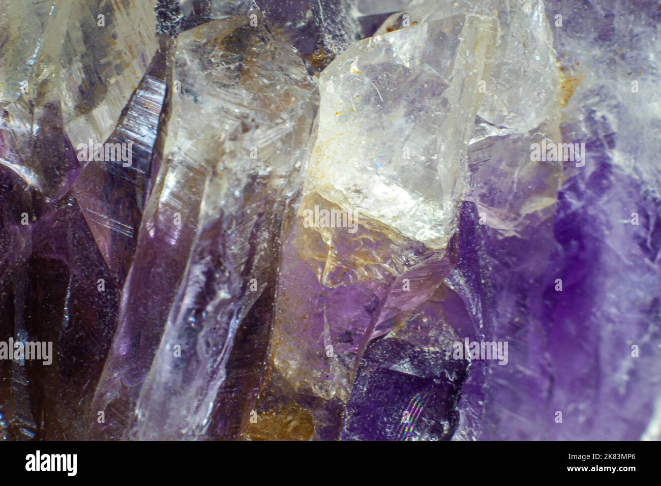 Ultra-Makro-Nahaufnahme eines natürlichen violetten Amethyst-Quarzanhäufens, isoliert auf schwarzem Hintergrund Stockfoto