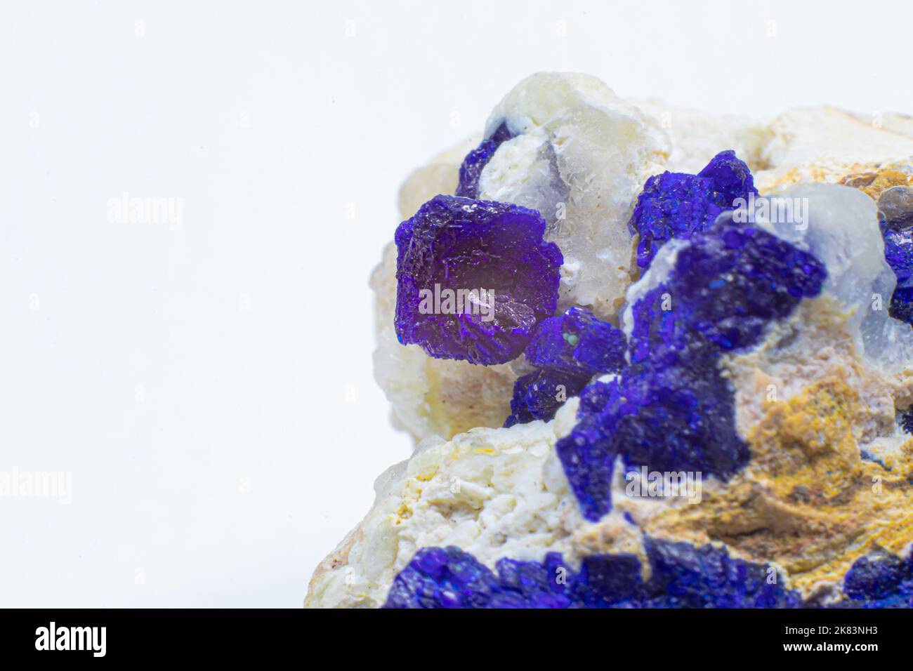 Makroblauer Azurit-Cluster auf weißem Matrix isolierter Kristall auf schwarzem Hintergrund Stockfoto