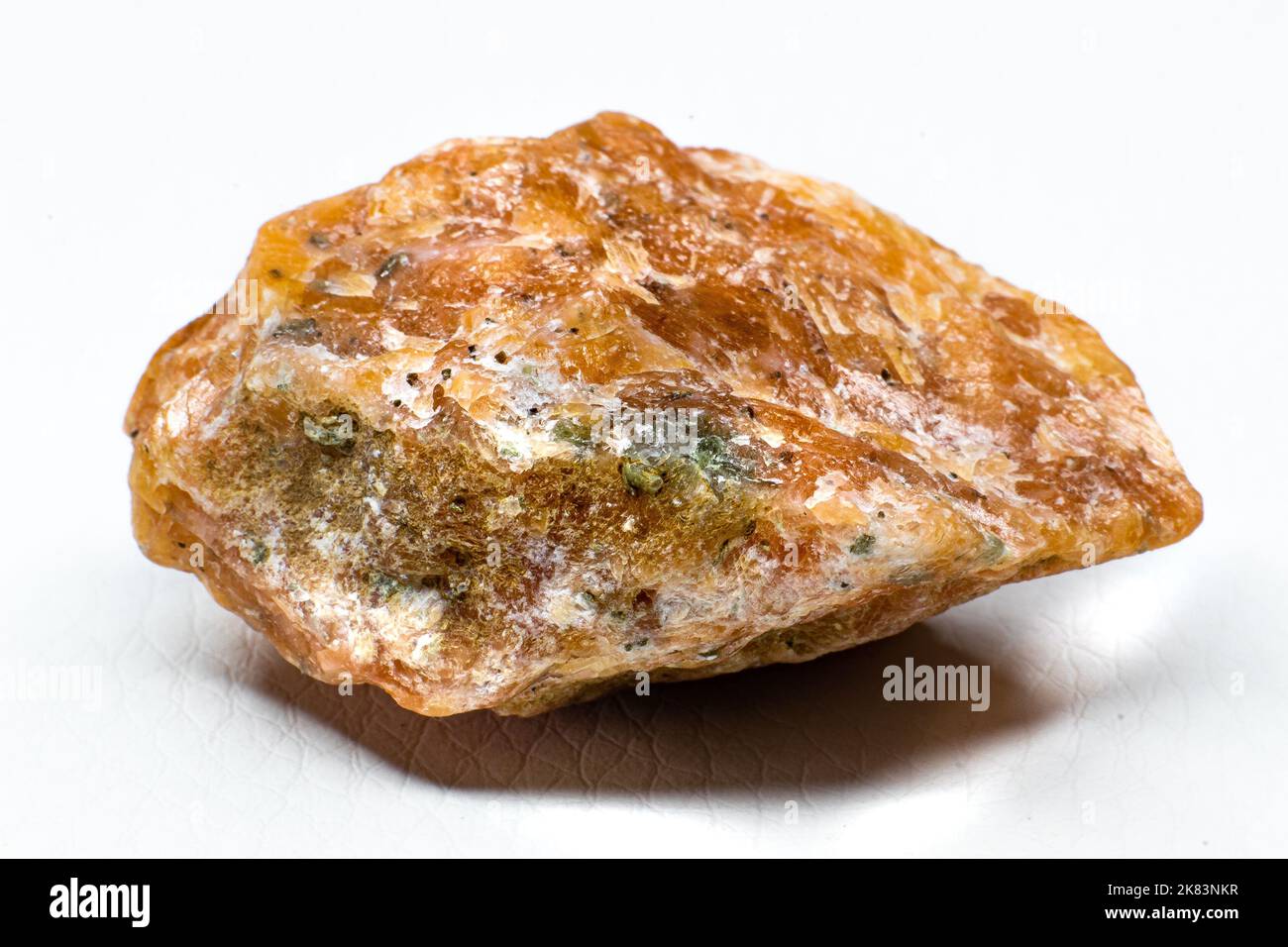 Rohes orangefarbenes Calcit-Stein-Makro auf weißem Hintergrund isoliert Stockfoto