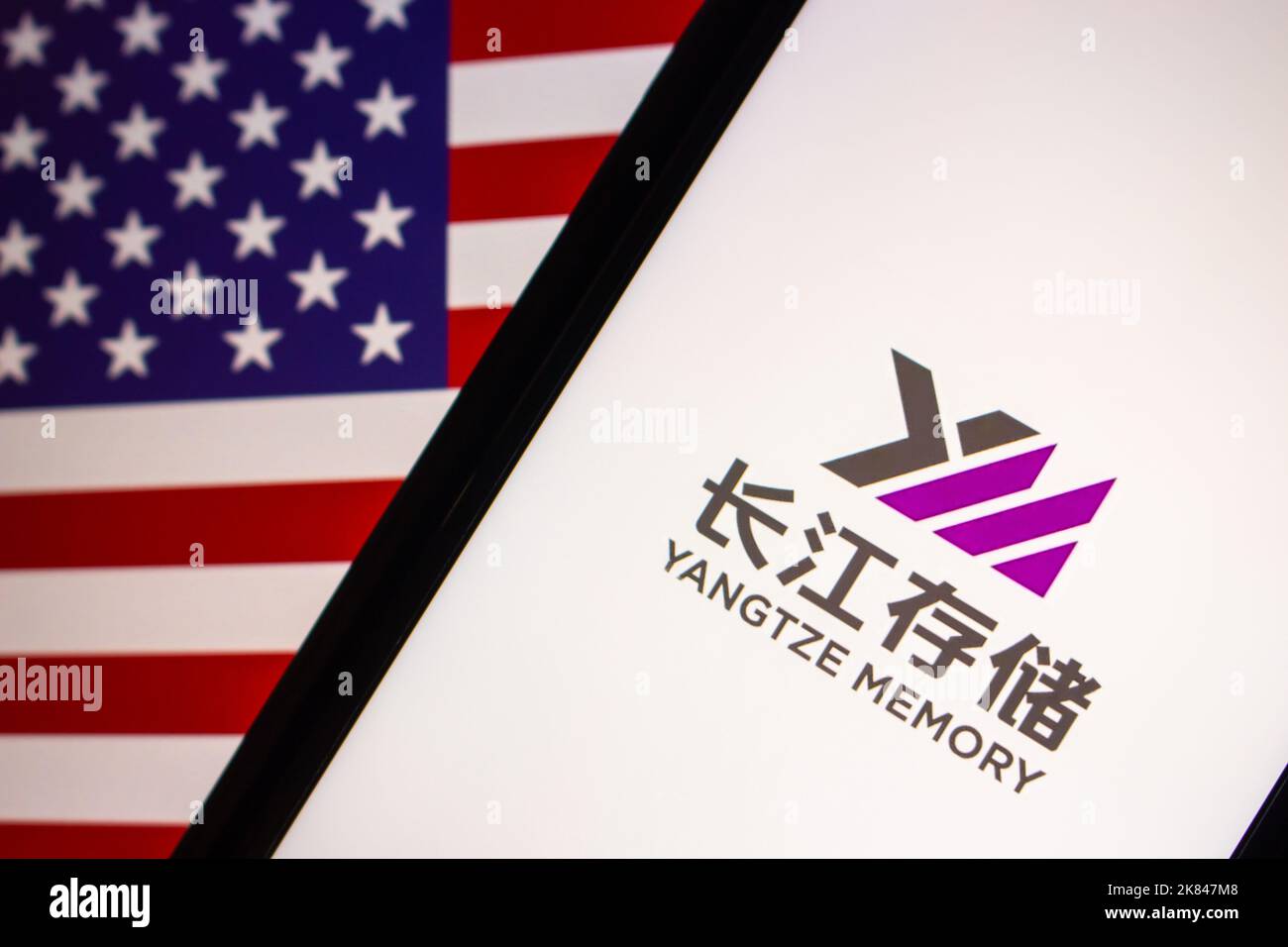 Logo von Yangtze Memory Technologies Corp auf dem iPhone auf US-Flagge. YMTC ist ein chinesischer Hersteller von integrierten Halbleiterbauelementen, der sich auf Flash-Speicher spezialisiert hat Stockfoto