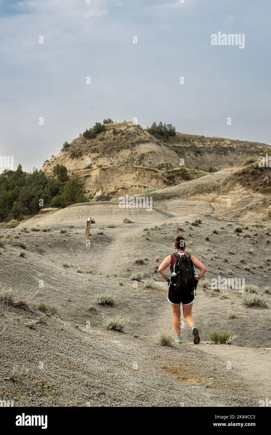 Wanderer, die entlang der Badlands-Formationen im Theodore Roosevelt National Park bergauf fahren Stockfoto