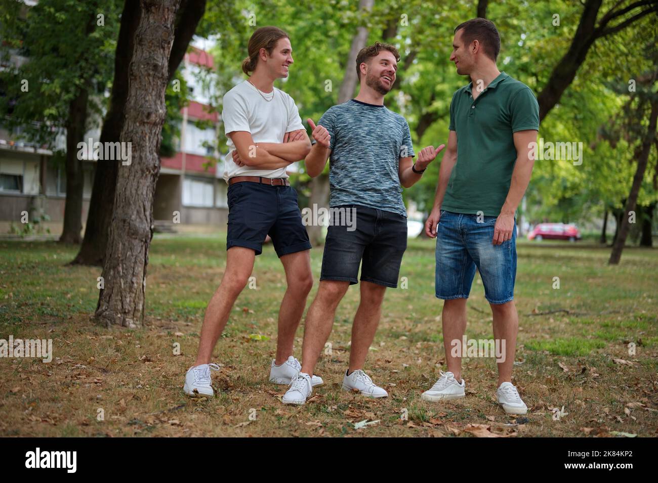 Drei hübsche junge Männer, die in einem Park Spaß haben Stockfoto