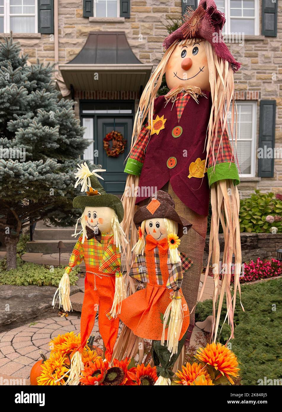 Herbst- und Halloween-Deko-Familienpuppen mit Blumen vor dem Haus, Kanada Stockfoto