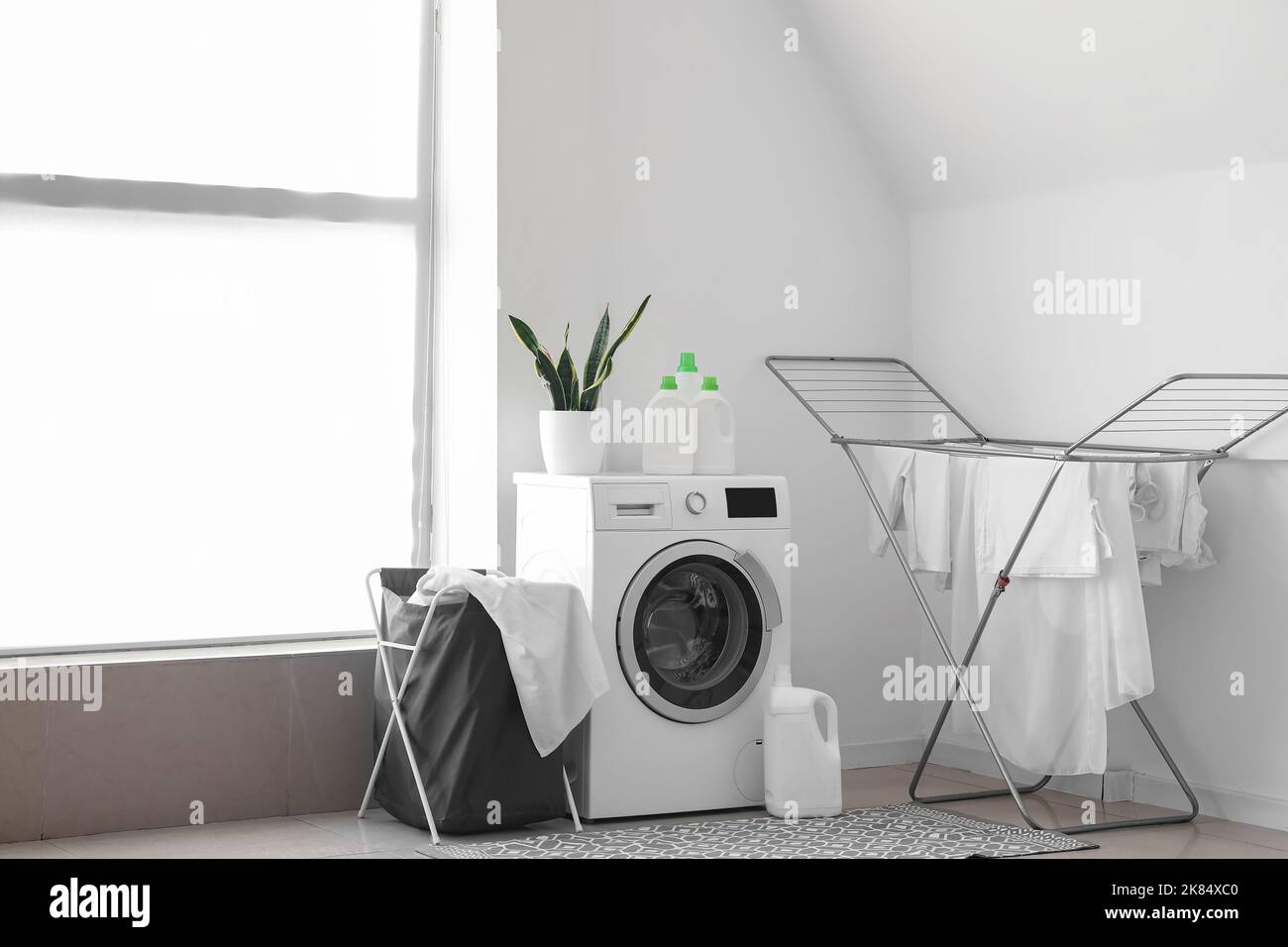Innenraum des hellen Waschraums mit Waschmaschine, Korb und Trockner  Stockfotografie - Alamy