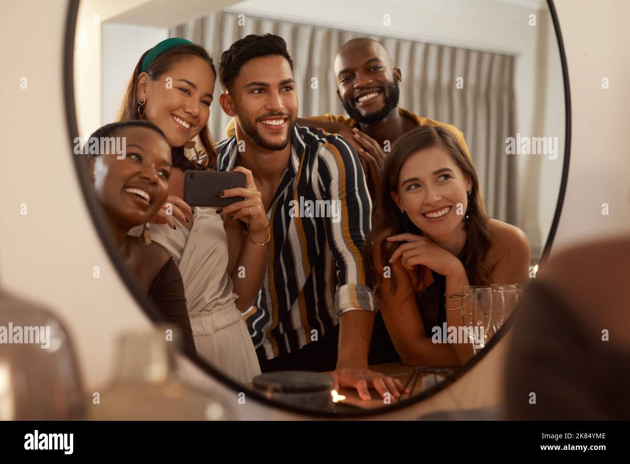 Mögen wir weiterhin gemeinsam epische Erinnerungen schaffen. Eine junge Gruppe von Freunden, die ein Handy benutzen, um während einer Neujahrsfeier Selfies zu machen. Stockfoto