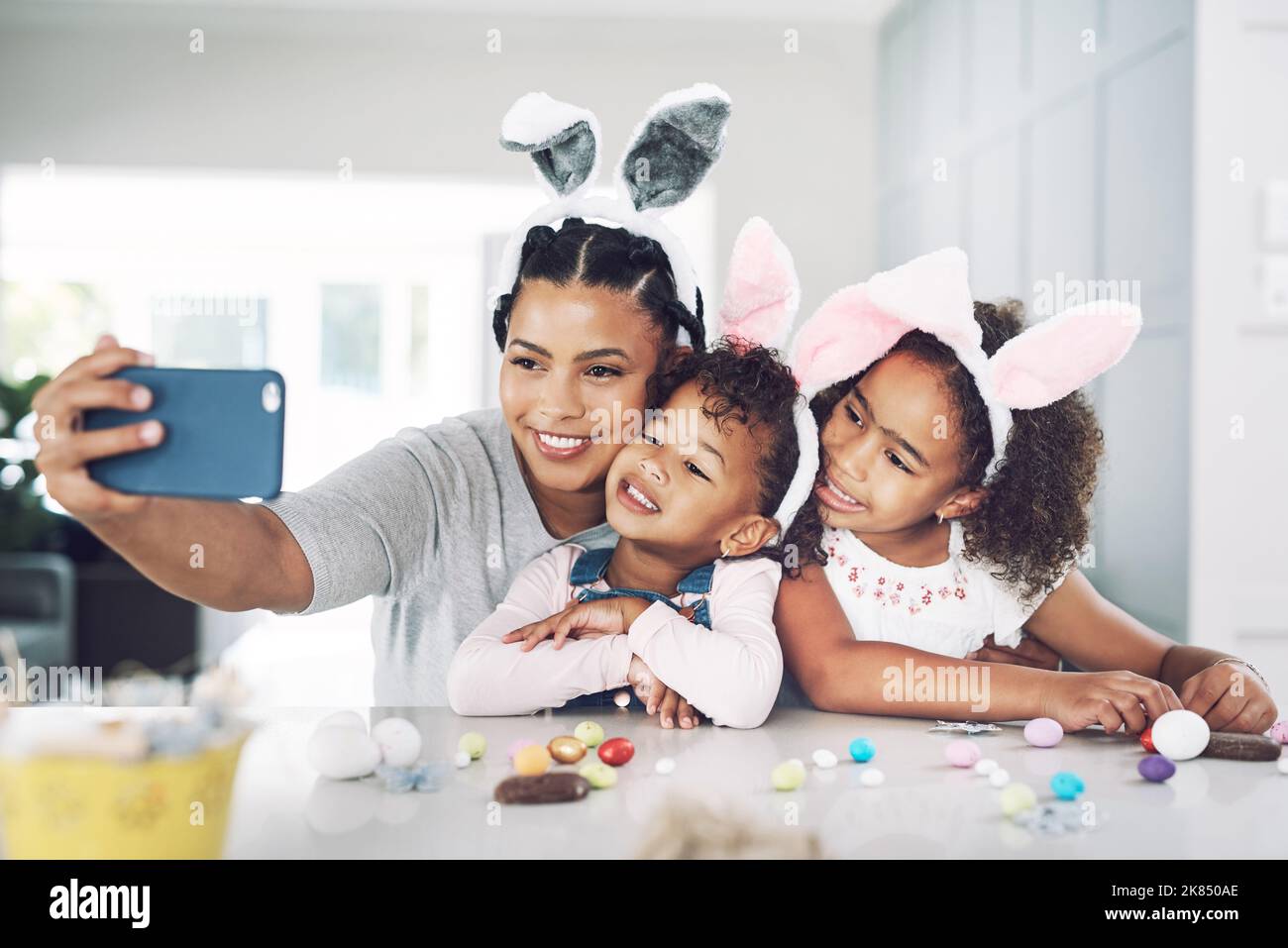 Ostern mit den süßesten Küken, die ich kenne. Eine Mutter, die zu Hause ein Selfie mit ihren Töchtern gemacht hat. Stockfoto