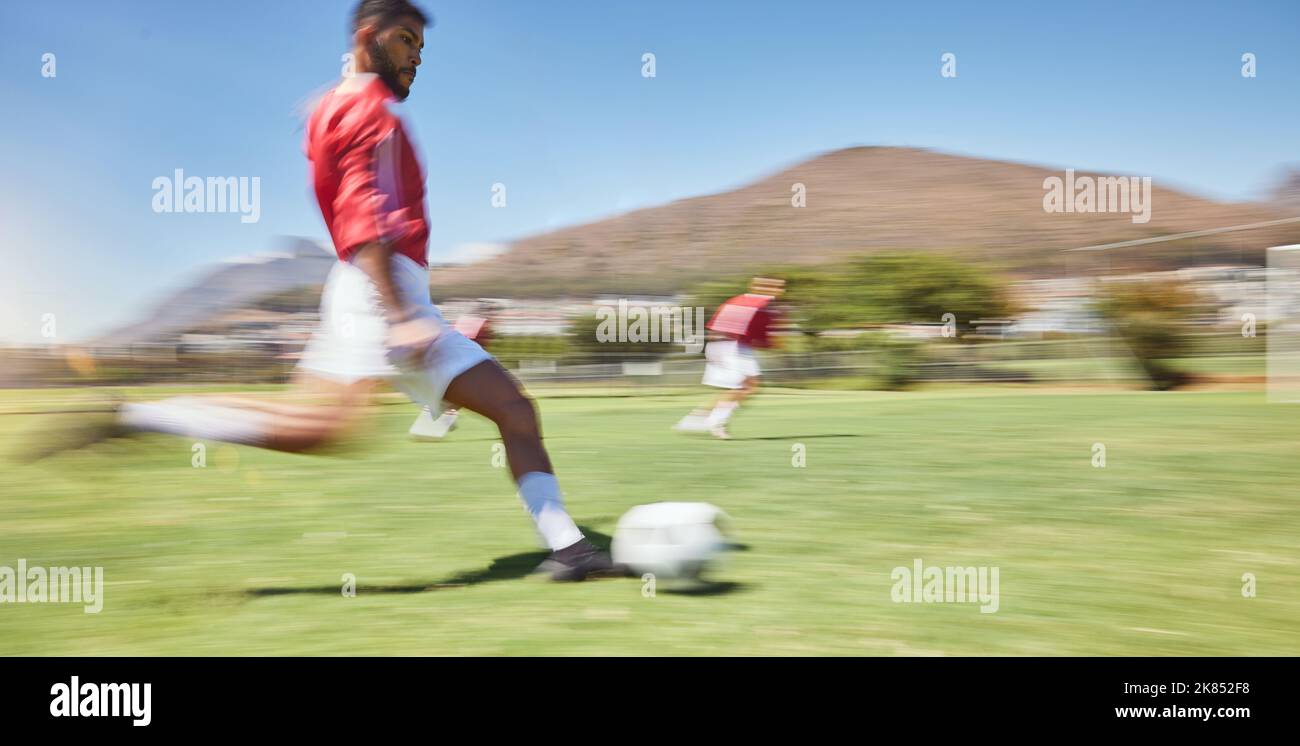 Action, Fußballspieler und Mann treten Fußball auf dem Rasen, Sportwettkampf und Teamspiel, Tore und Gewinnchancen. Fußballfeld mit Bewegungsunschärfe Stockfoto