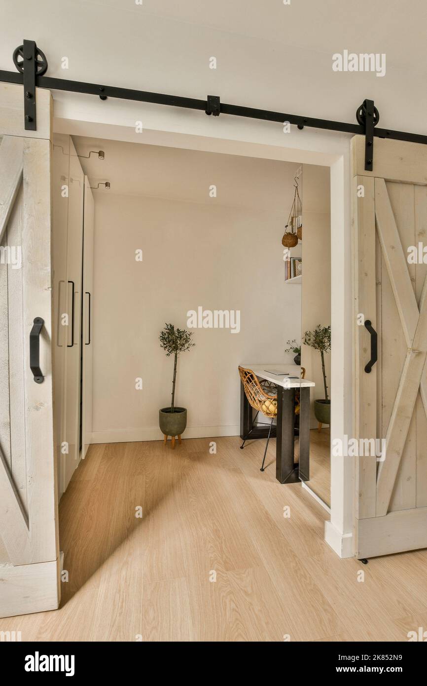 Zimmer mit Retro-Tür zum Arbeitszimmer und Korridor in Perspektive im modernen Haus Stockfoto