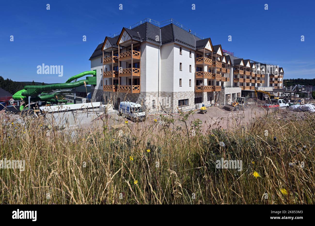 Oberhof, Deutschland. 28.. Juli 2022. Im Stadtzentrum wird ein Familienhotel gebaut. Der Bau des fünf-Sterne-Hotels sollte Ende 2019 beginnen, ein österreichischer Unternehmer hatte für den Neubau rund 50 Millionen Euro eingeplant. Das Haus mit 110 Zimmern und 15 Chalets wird in diesem Jahr eröffnet. Quelle: Martin Schutt/dpa/Alamy Live News Stockfoto
