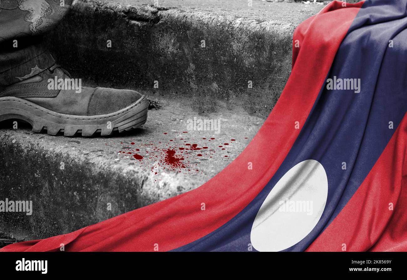 Das Bein des Militärs steht auf der Stufe neben der Flagge von Laos, dem Konzept des militärischen Konflikts Stockfoto