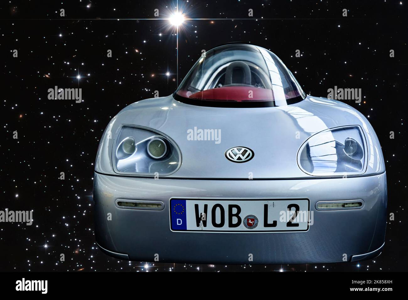 VW L2 1-Liter-Auto, Vorderansicht eines stromlinförmigen Fahrzeugs, verbraucht nur einen Liter Diesel für 100 Kilometer, zusammengesetzt gegen futuristische Sterne Stockfoto