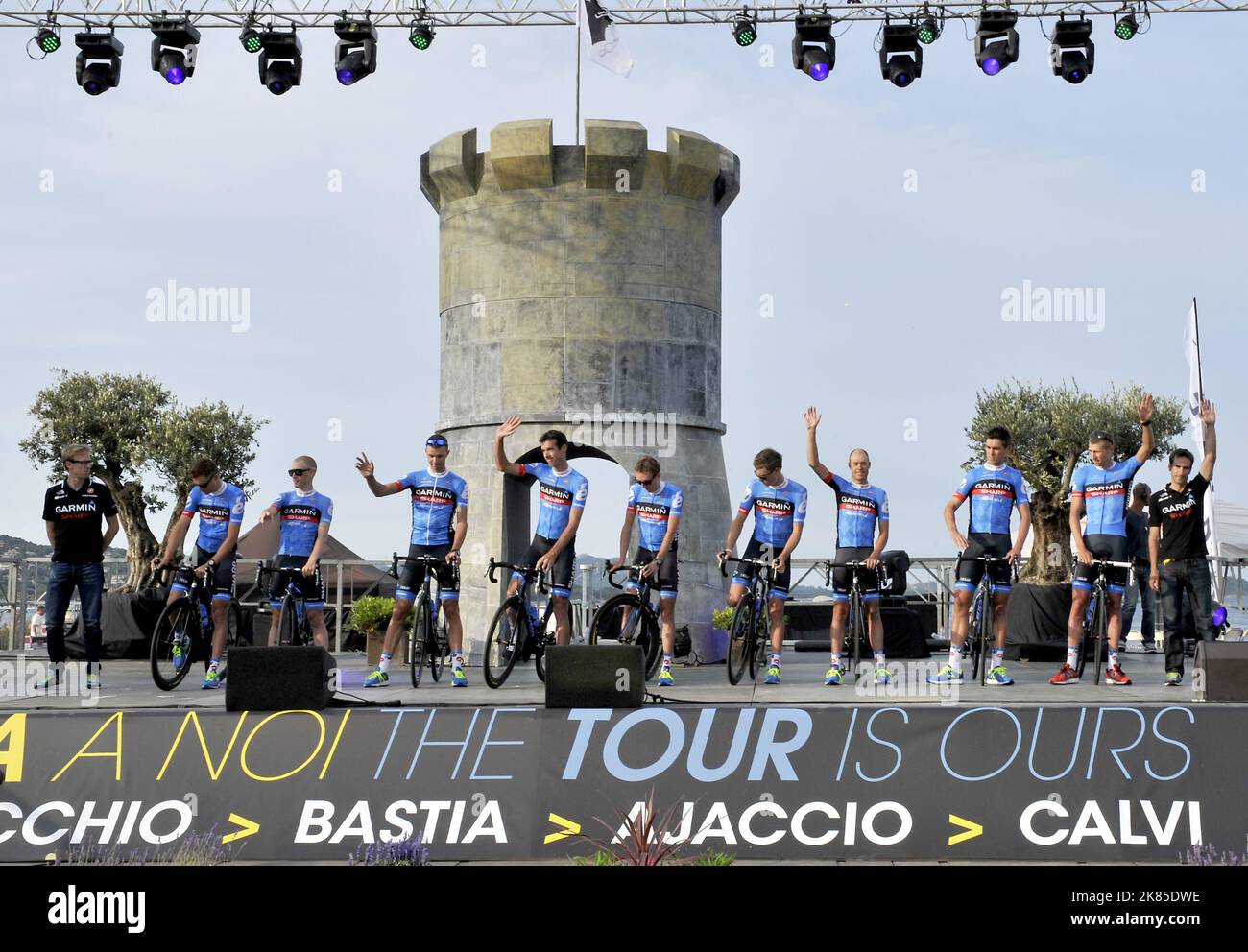 Das Team Garmin Sharp kommt auf die Bühne, wo das Team für die Tour de France 100. in Portoo vecchio ansteht. Mit dem Fahrrad von einem im Hafen verankerten Motorboot auf die Bühne. Darunter: Ryder Hesjedal, Jack Bauer, Thomas Danielson, Rohan Dennis, Daniel Martin, David Millar, Navardauskas, Andrew Talansky und Christian Vandevelda. Stockfoto