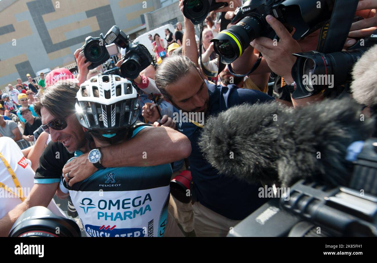 Matteo Trentin ist auf der Ziellinie von den Medien umgeben, nachdem er die Etappe gewonnen hat, während ihm der Regisseur Sportif Davide Bramati gratuliert. Stockfoto