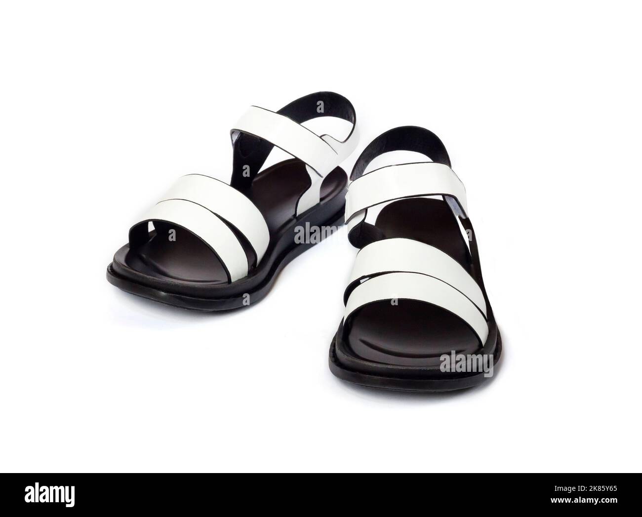 Paar schwarze und weiße weibliche Sandalen isoliert auf weißem Hintergrund Stockfoto