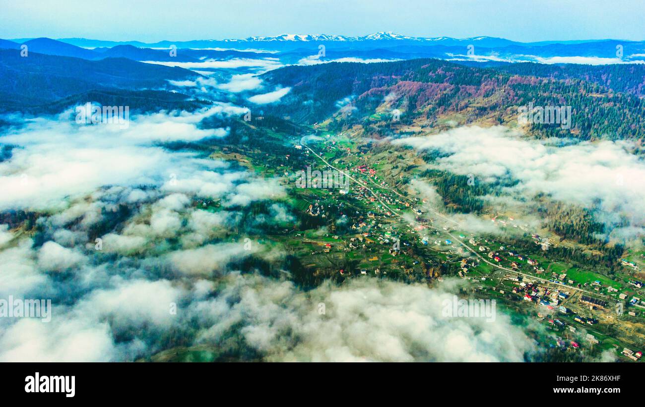 Wunderschöne Naturlandschaft Nebel im Tal und in den Bergen am Aussichtspunkt aus dem hohen Winkel. Nebel und Wolken über der Stadt, um die Berge am Morgen Stockfoto