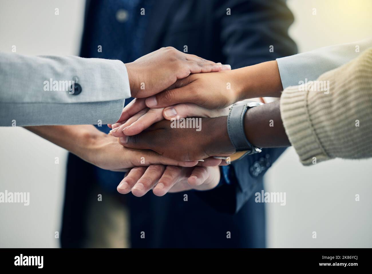 Lassen Sie uns unser gesamtes tun. Geschäftskollegen mit gestapelten Händen bei der Arbeit. Stockfoto