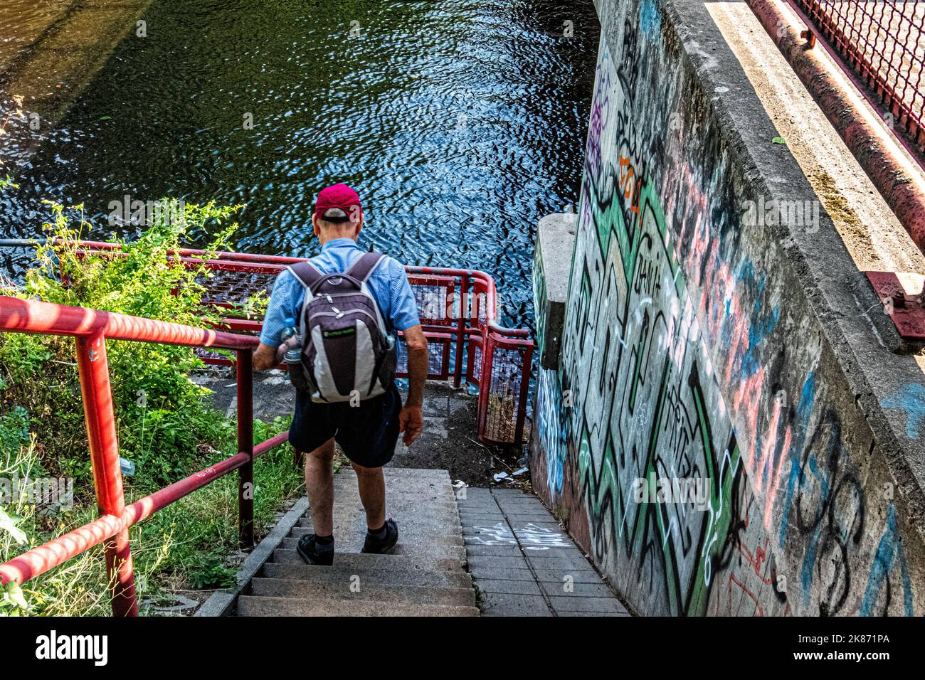 Ehemalige Berliner Mauerstraße. Älterer Mann steigt an der Chris-Güffroy-Brücke, Baumschulenweg, Treptow-Köpenick, Berlin, die Stufen hinab Stockfoto