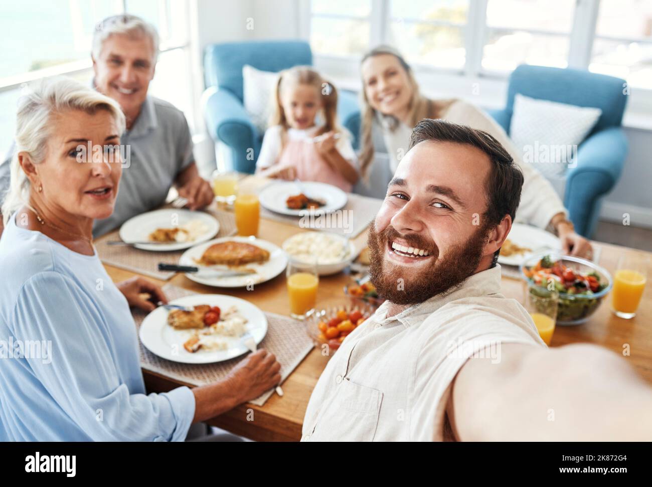 Liebe, Selfie und Essen mit der großen Familie zu Hause für fröhliche Fotos zusammen in Australien. Eltern, Großeltern und Kind am Esstisch Stockfoto