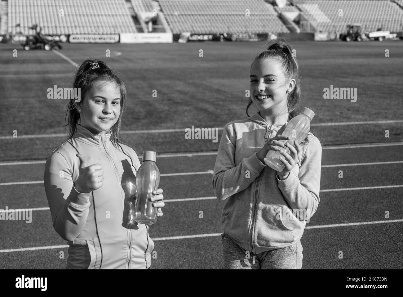 Glückliche Kinder halten Sportgetränke bereit. Sport und Flüssigkeitszufuhr. Wasser und Flüssigkeitszufuhr Stockfoto