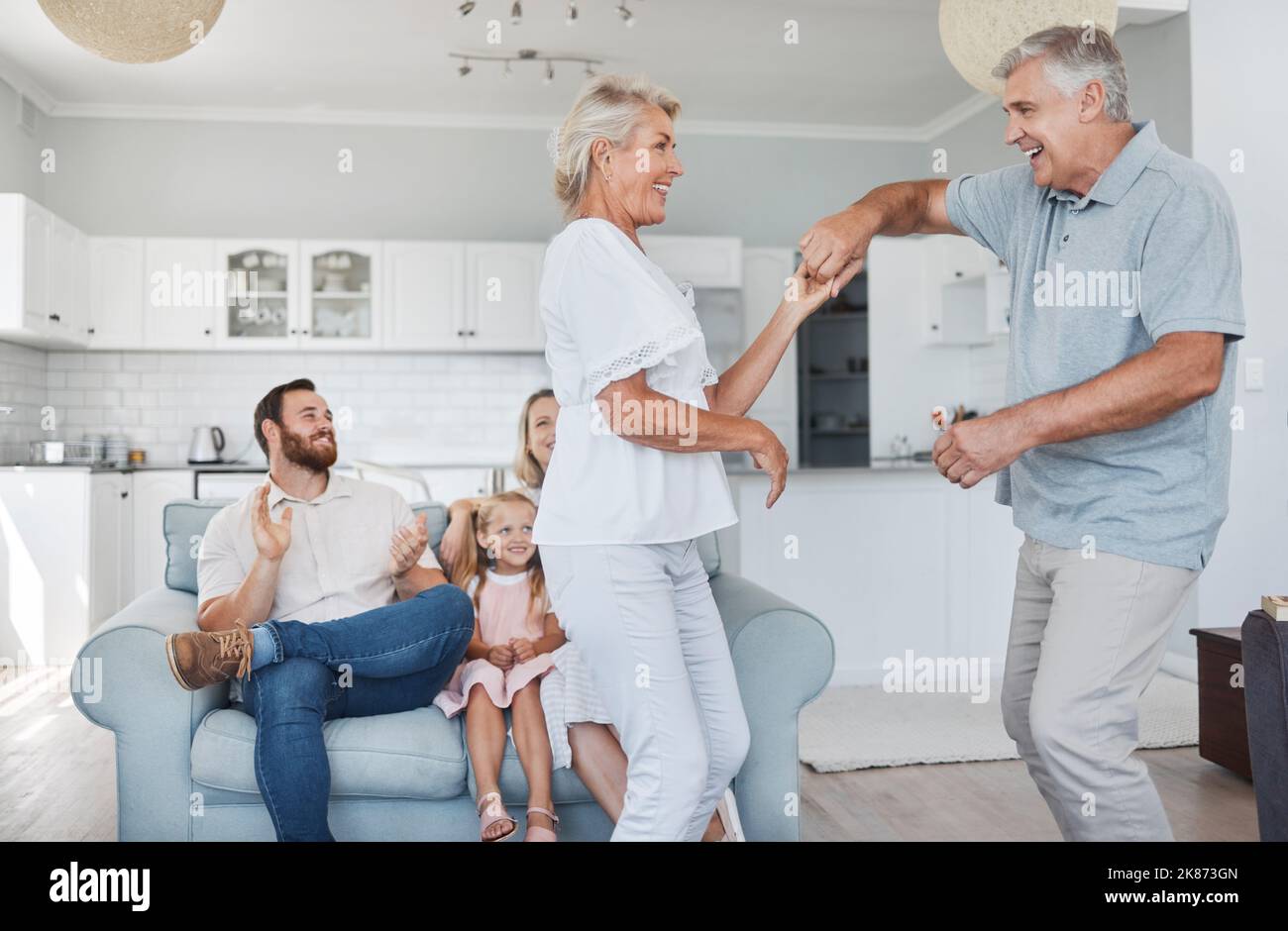 Ältere Paare tanzen zusammen für den Ruhestand, Familie oder Ehe Feier mit Glück mit Kind im Hintergrund. Ältere Rentner tanzen zu Stockfoto