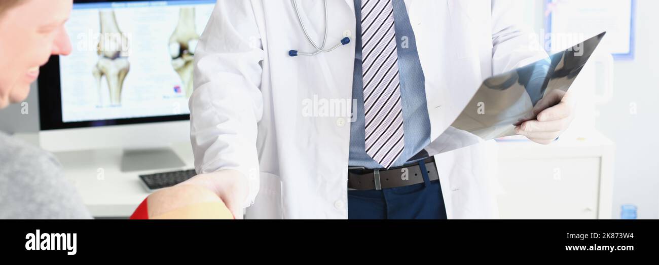 Arzt tragen Uniform und Untersuchung Patienten-Scan, berühren mans Knie Stockfoto