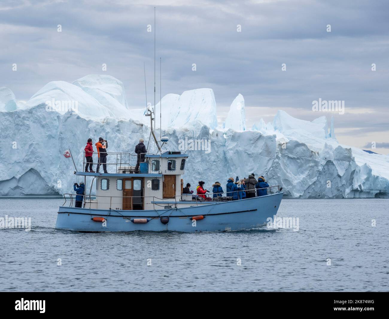 Touristen, die eine Eistour in einem kleinen Boot machen und Eisberge vom Ilulissat-Eisefjord aus beobachten, etwas außerhalb von Ilulissat, Grönland, Dänemark, Polarregionen Stockfoto