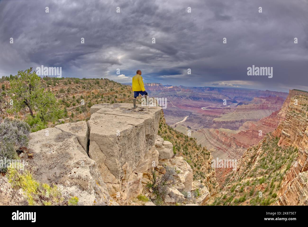 Ein Wanderer, der an einem stürmischen Tag auf einer Klippe zwischen Zuni und Papago Points am Grand Canyon, dem Grand Canyon National Park, UNESCO, Arizona, steht Stockfoto