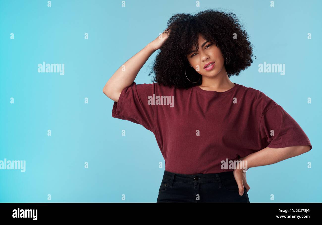 Könnten Sie das wiederholen. Studioaufnahme einer jungen Frau, die verwirrt vor blauem Hintergrund aussieht. Stockfoto