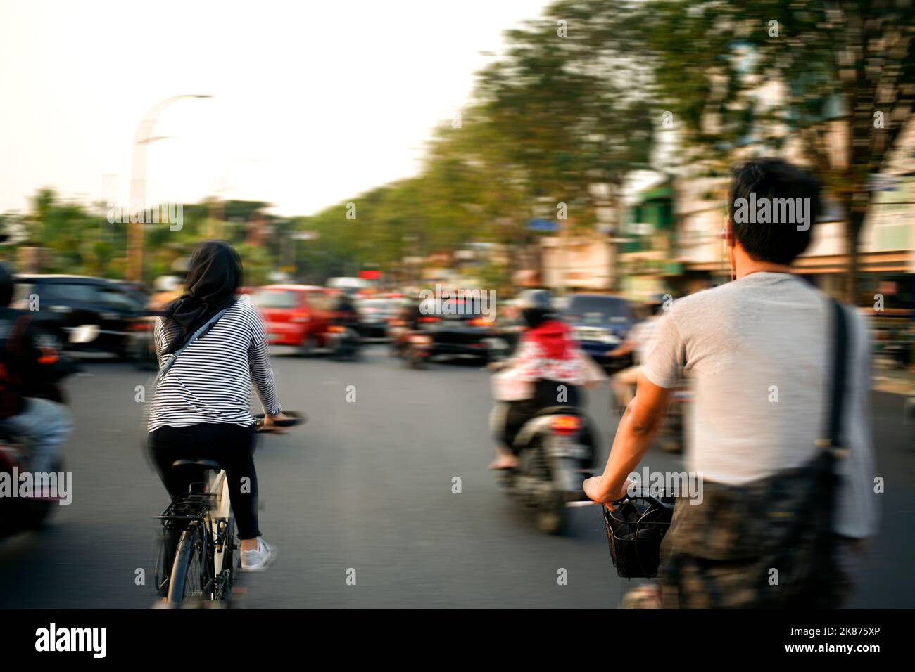 Zwei Personen Fahrrad fahren auf asia City Street. Rush Hour. Bewegung verschwimmen. Stockfoto