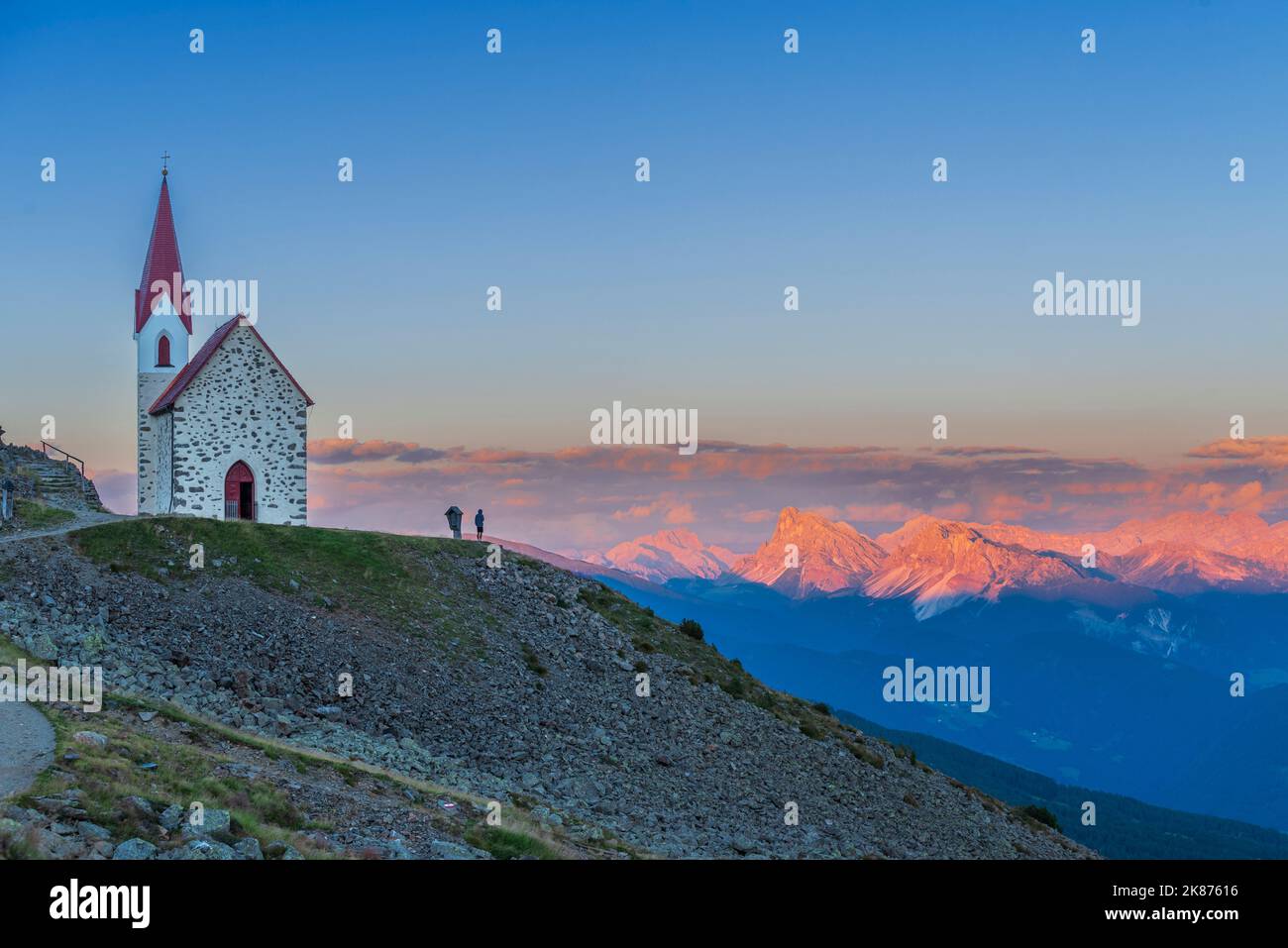 Der Mensch genießt den Sonnenuntergang über den Dolomiten an der Wallfahrtskirche von Lazfons, Klausen, Bozen, Südtirol, Italien, Europa Stockfoto