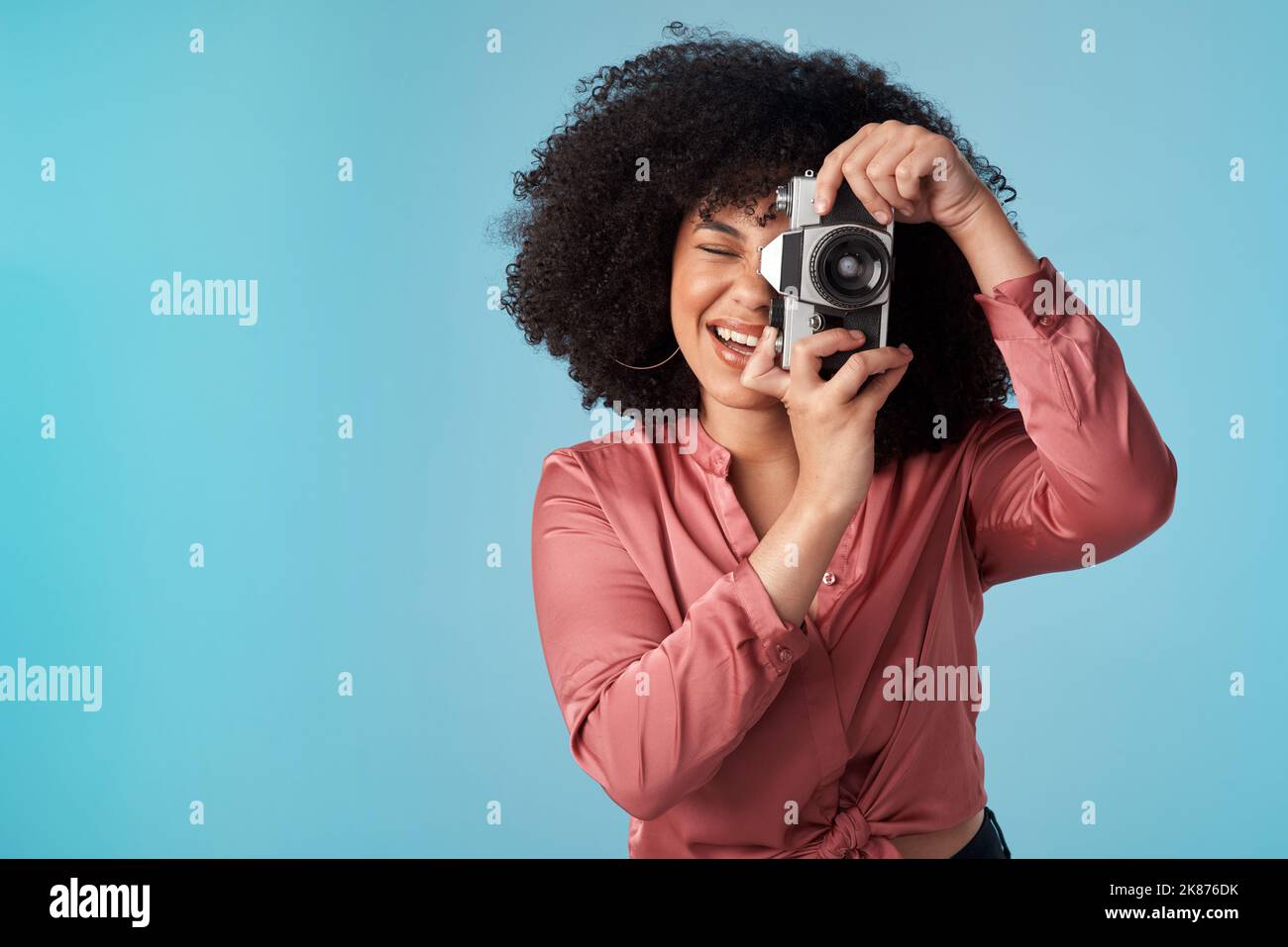 Du gibst mir einige tolle Erinnerungen für meine Sammlung. Studioaufnahme einer jungen Frau mit einer Kamera vor blauem Hintergrund. Stockfoto Du gibst mir einige tolle Erinnerungen für meine Sammlung. Studioaufnahme einer jungen Frau mit einer Kamera vor blauem Hintergrund. Stockfoto