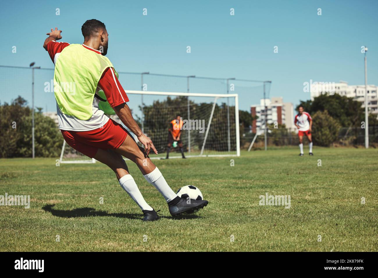 Fußball, Sport und Männer auf einem Feld während eines Spiels, Trainings oder gemeinsamen Trainings. Sportler tritt einen Fußball während eines professionellen Wettkampfs, einer Veranstaltung oder Stockfoto