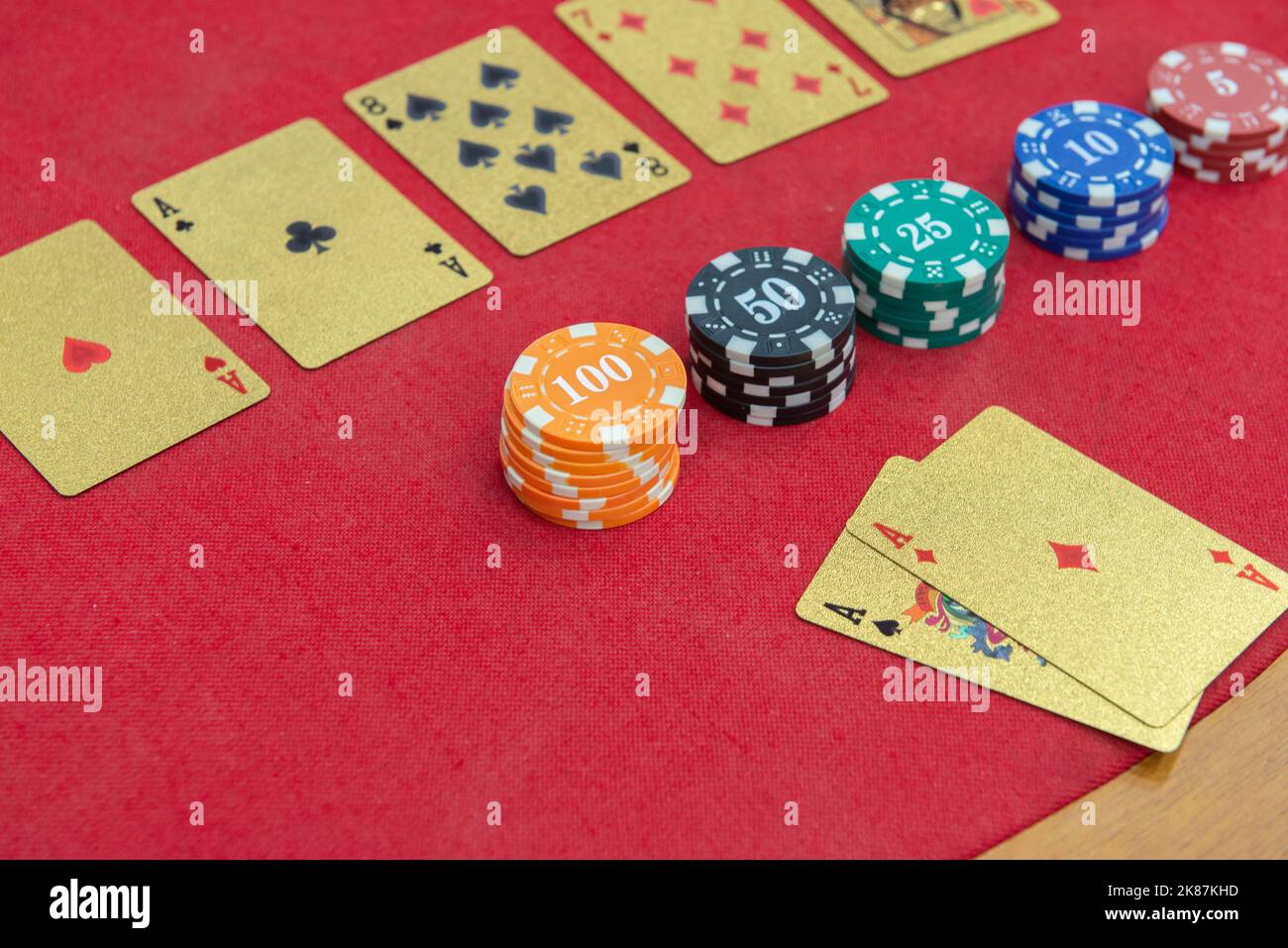 Texas Holden Poker Tisch mit goldenen Spielkarten und im Format eines 100-Dollar-Scheines neben den Wettchips. Poker und Black Jack sind sehr Pop Stockfoto