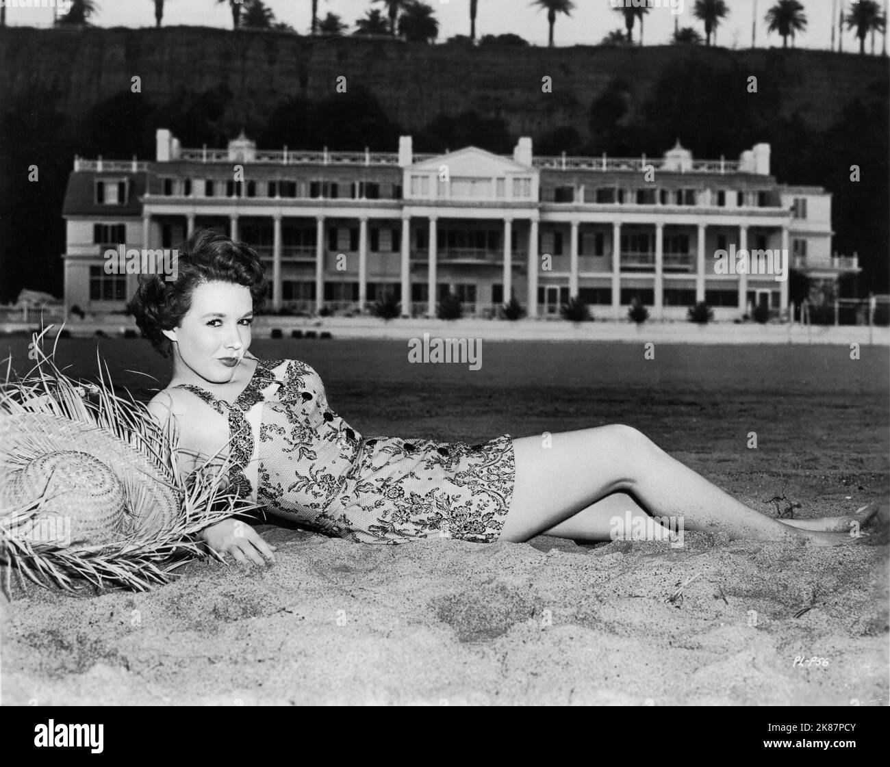 PIPER LAURIE 1951 Badeanzug-Pin-up-Pose am Santa Monica Beach mit dem Marion Davies Beach House im Hintergrund für Universal Picturs Stockfoto