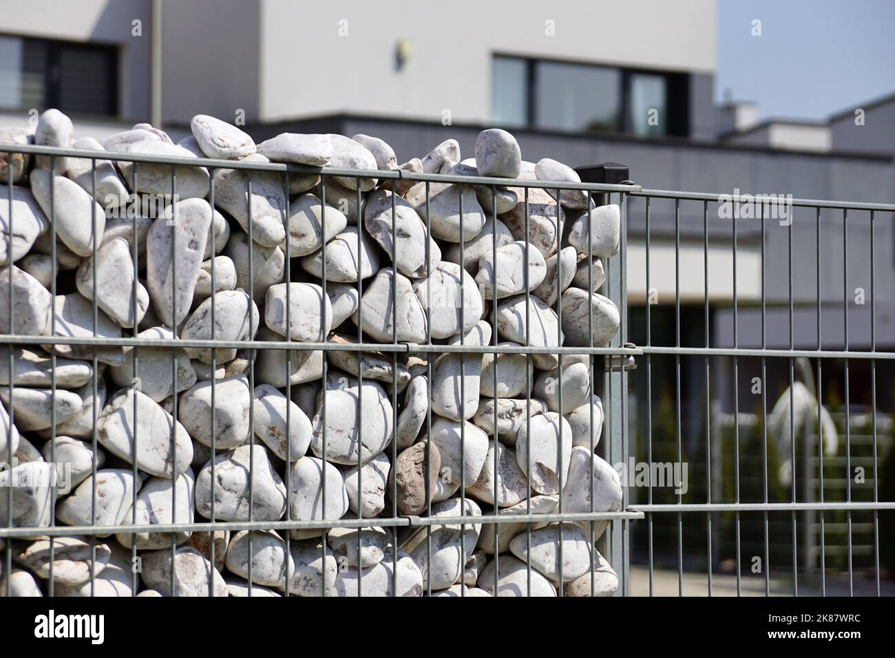 Gabionen als architektonische Elemente, die die Einzäunung von Gebäuden bilden. Architektur der Stadt. Stockfoto