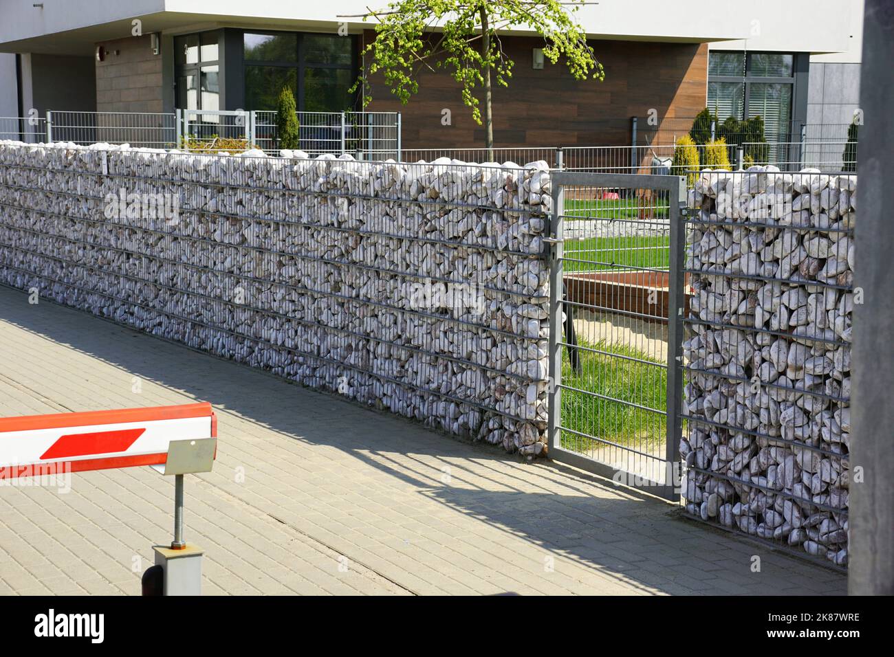 Automatisches Eingangstor in Kombination mit einer Wand aus Gabion. Stockfoto