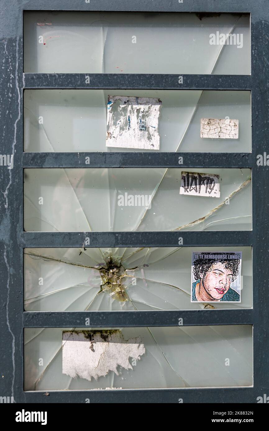 Französisches Fenster mit zerbrochenem Glas, mit ein paar zerrissenen Postern Stockfoto