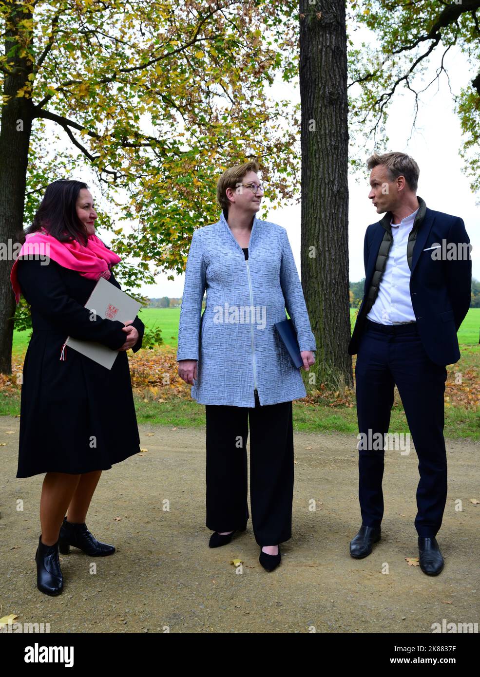 21. Oktober 2022, Brandenburg, Cottbus/OT Branitz: Stefan Körner (r), Direktor der Prinz-Pückler-Park- und Schloss-Branitz-Stiftung (SFPM), Klara Geywitz (M, SPD), Bundesministerin für Bau und Wohnen, und Manja Schüle (l, beide SPD), Brandenburgische Ministerin für Wissenschaft, Forschung und Kultur, sprechen im Branitz-Park. Vorgestellt wurde das Modellprojekt der Bundesregierung "New Tree University Branitz" zur Erhaltung historischer Gärten im Klimawandel. Auf dem Gelände eines ehemaligen Marktgartens soll eine neue Ära der 176-jährigen Branitz-Baumuniversität entstehen. Das Außenpar Stockfoto