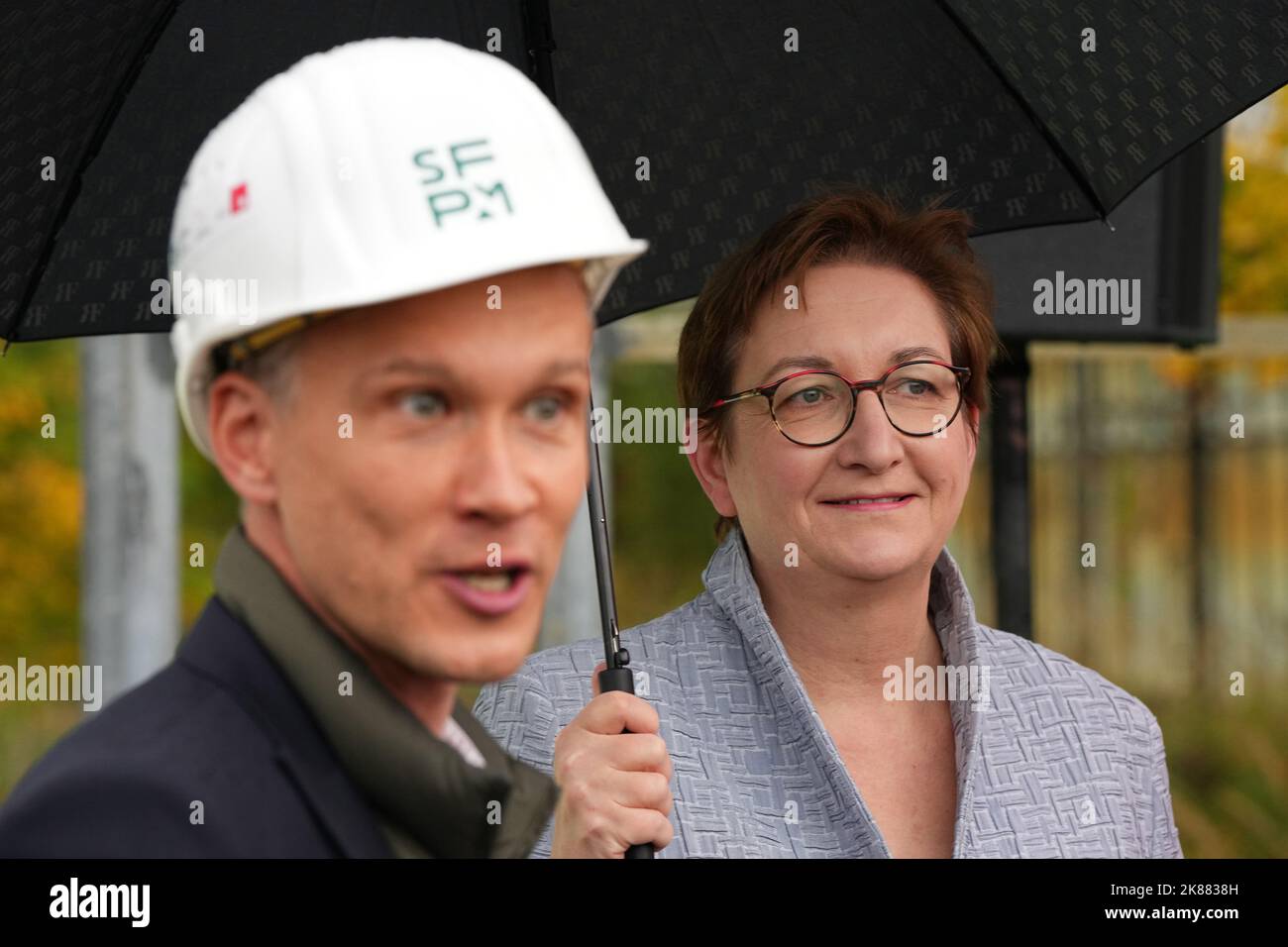 21. Oktober 2022, Brandenburg, Cottbus/OT Branitz: Stefan Körner, Direktor der Stiftung Prinz-Pückler-Museumspark und Schloss Branitz (SFPM), und Klara Geywitz (SPD), Bundesministerin für Bau und Wohnen, stehen auf dem Gelände der zukünftigen "Neubau-Universität" unter einem Dach im Freigelände Branitz. Vorgestellt wurde das Modellprojekt 'New Tree University Branitz' der Bundesregierung zur Erhaltung historischer Gärten im Klimawandel. Auf dem Gelände eines ehemaligen Marktgartens soll eine neue Ära der 176 Jahre alten Branitz Tree University entstehen. Die Outdoor-p Stockfoto