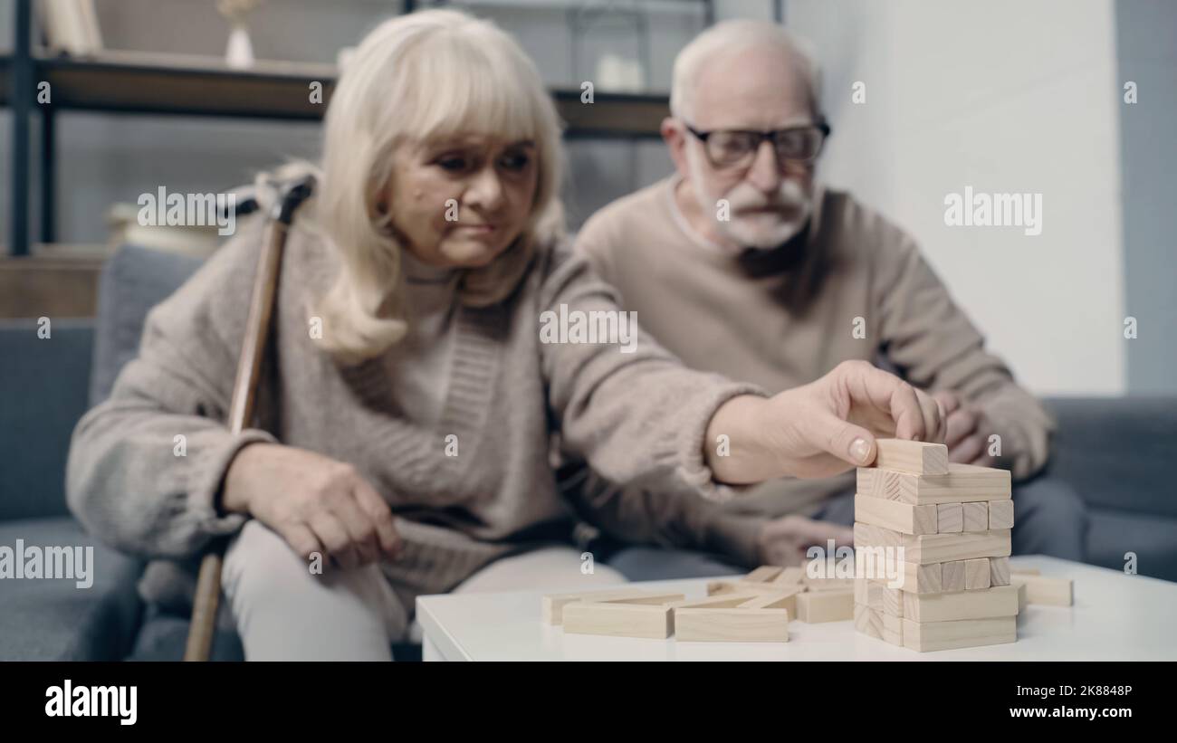Ältere Paare mit Demenz spielen mit Holzblöcken im Turmspiel zusammen Stockfoto