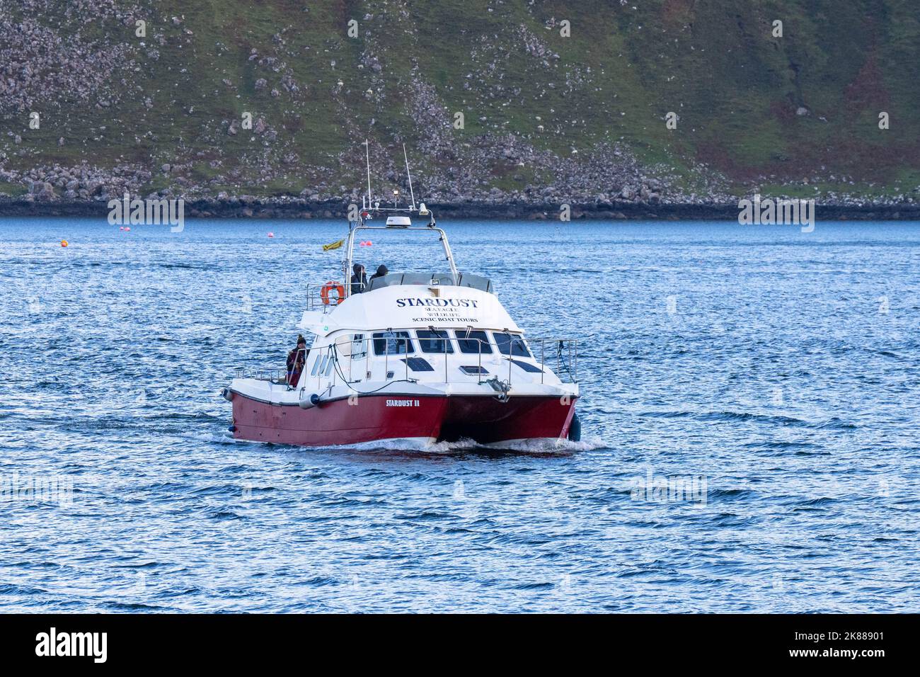 Menschen, die mit dem Boot Stardust zurück in den Hafen kommen, nachdem sie auf der Portree Isle of Skye eine Wildtierfahrt um die Berge gemacht haben Stockfoto
