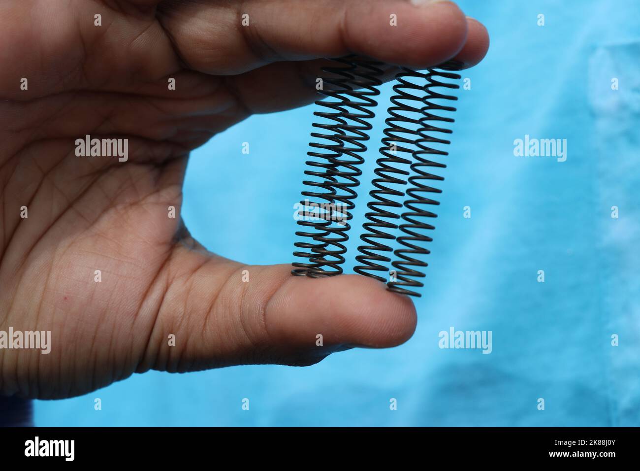 Druckfedern aus Metall, mit denen Stöße von verschiedenen Lastteilen in der Hand absorbiert werden Stockfoto