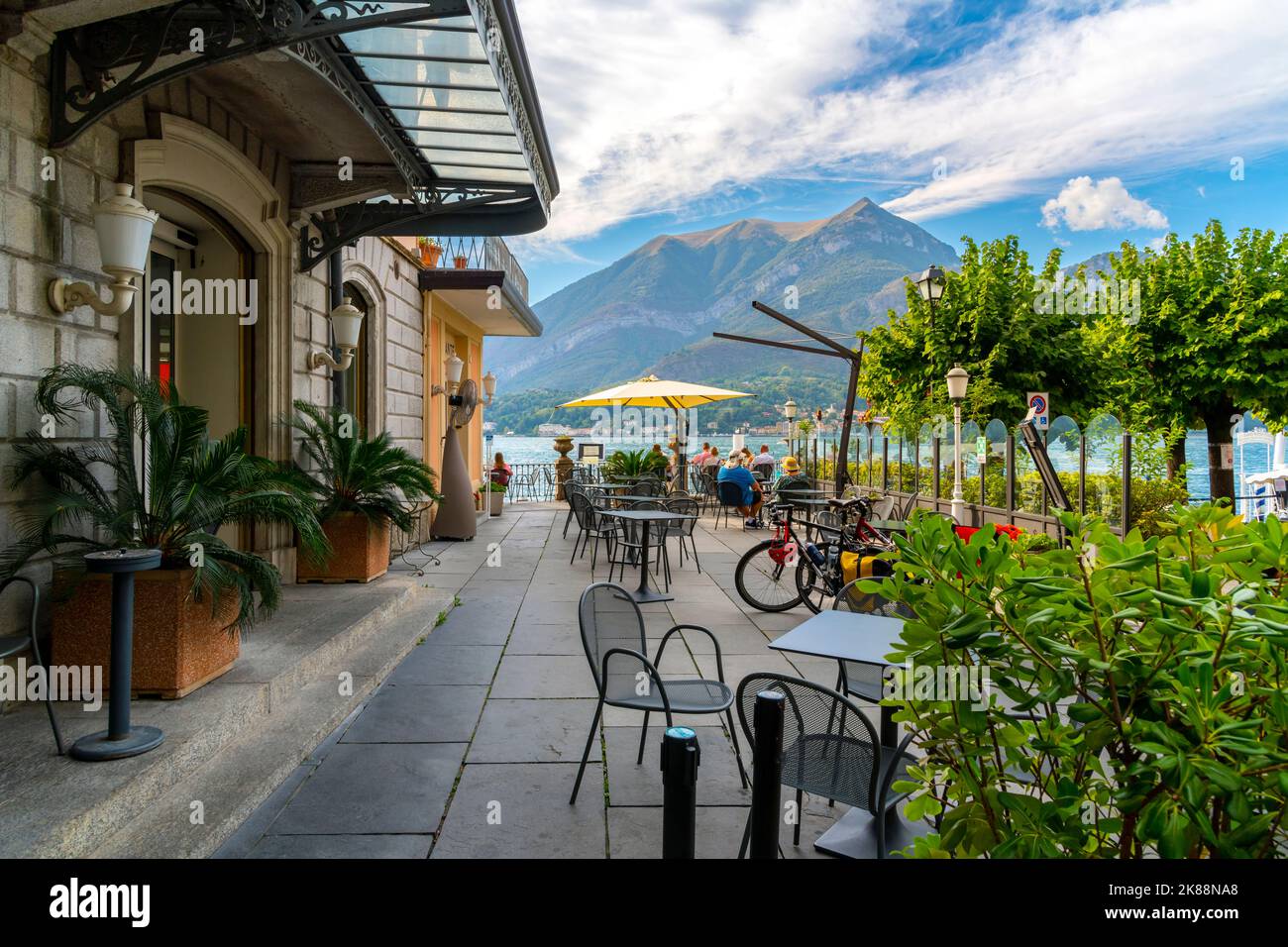 Touristen essen im Sommer in einem Freiluftcafé am Ufer des Comer Sees in der malerischen Stadt Bellagio, Italien. Stockfoto