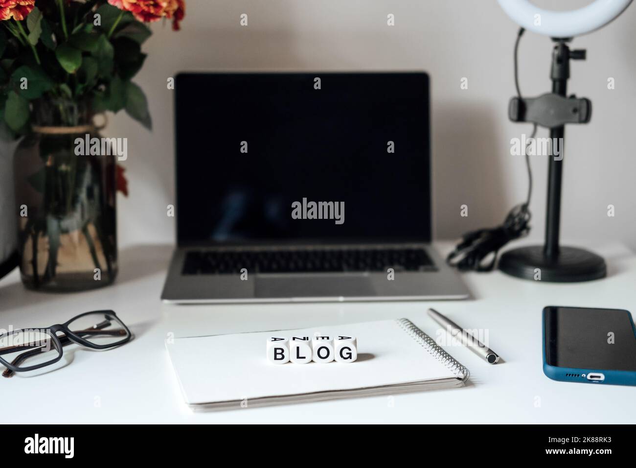 Blogging-Ausrüstung. So starten Sie den Blog, Bloggen für Anfänger. Laptop, Mobiltelefon, Ringlicht, Notebook und Brille auf dem Tisch Stockfoto