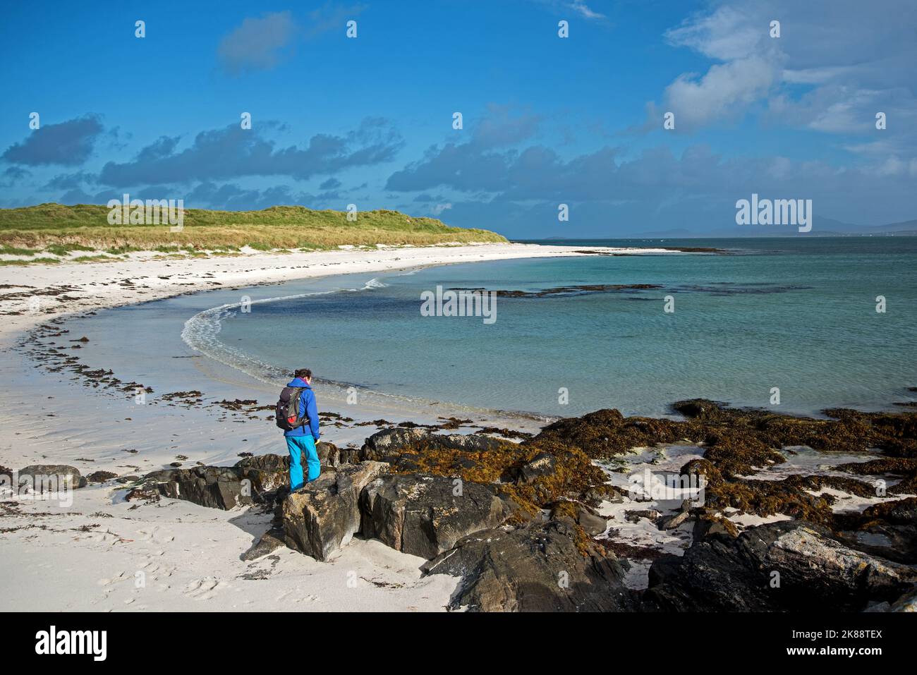 Junge Frau erkundet Traigh Sgurabhal, einen weißen Sandstrand in Eoligarry, Isle of Barra, Äußere Hebriden, Schottland, Großbritannien. Stockfoto