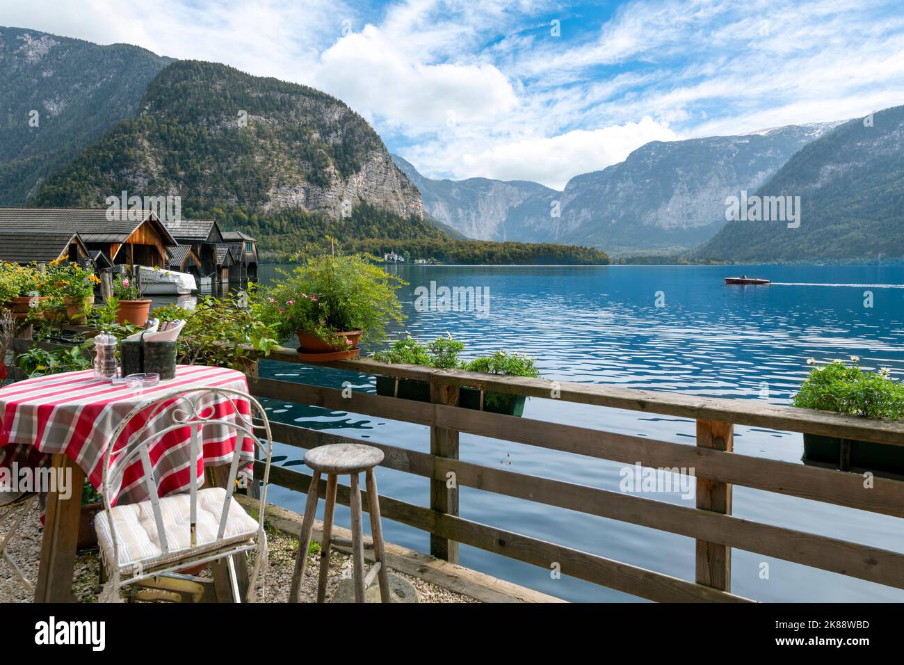 Ein kleiner Tisch in einem Café im Freien mit Blick auf den See und die Alpen in der österreichischen Bergstadt Hallstatt. Stockfoto