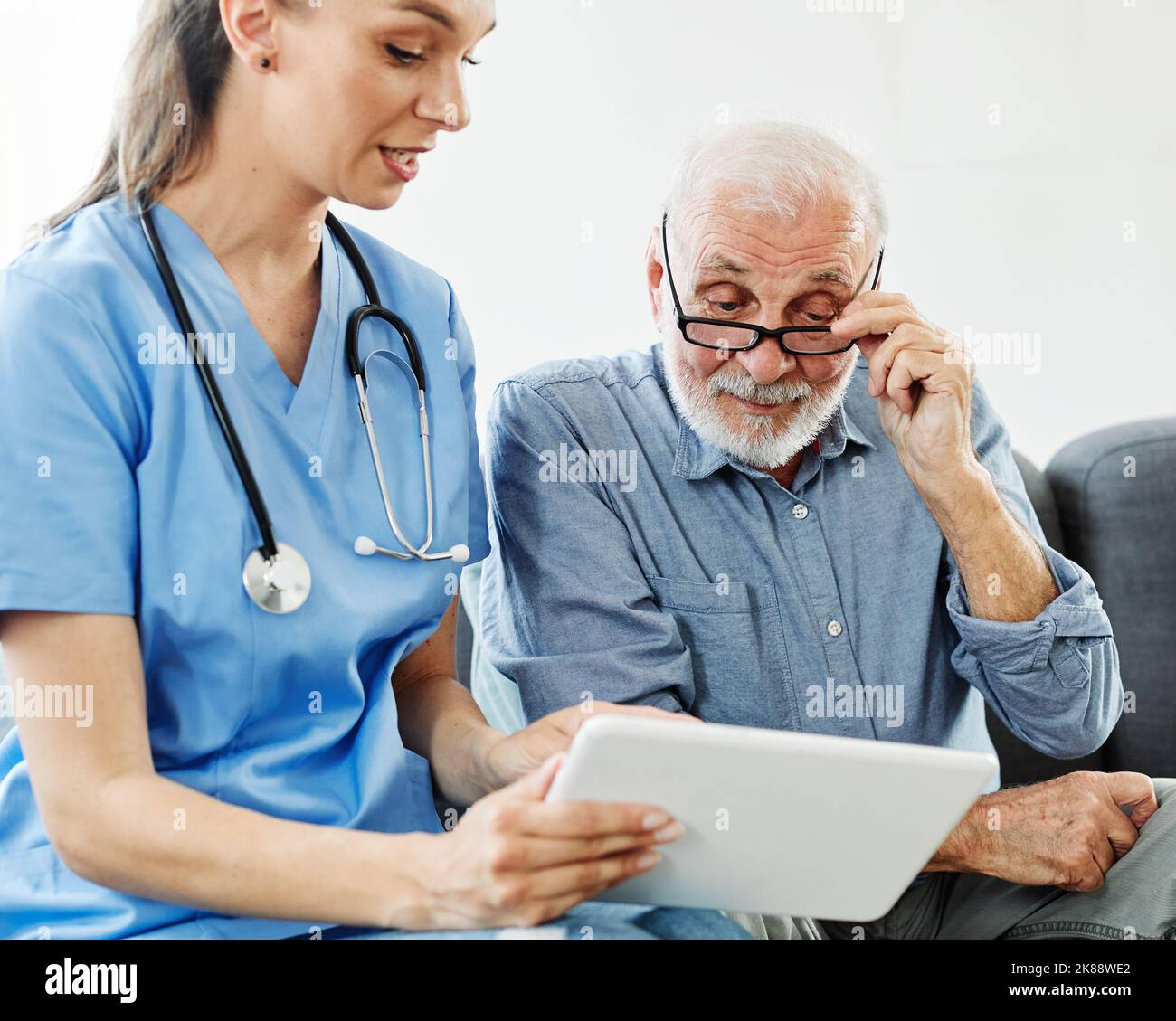 Schwesternarzt Seniorenbetreuung Tablet-Computer-Technologie zeigt Betreuer Hilfe Unterstützung Altersheim Krankenpflege älteren Mann Stockfoto