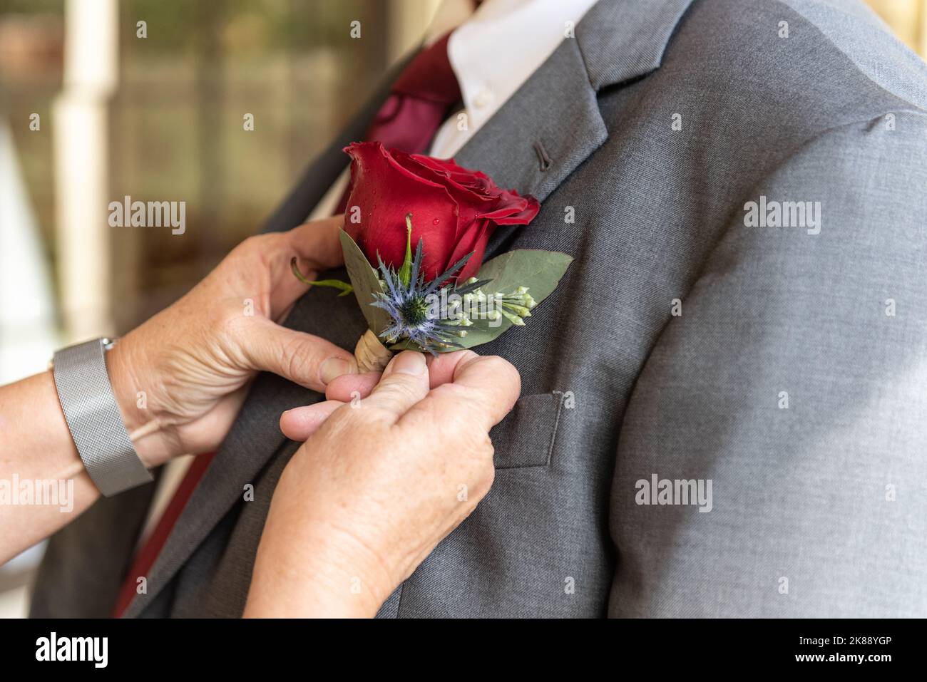 Seitenansicht der formellen Jacke von mans mit dem letzten Schliff eines Boutonniere zum Revers hinzugefügt. Stockfoto