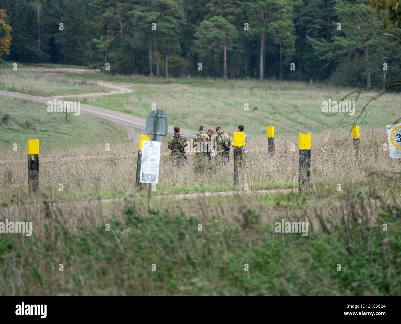Mehrere Soldaten der britischen Armee mit teleskopierbaren Gewehren ausgestattet, Kartenlesung in Vorbereitung auf eine militärische Übung Stockfoto