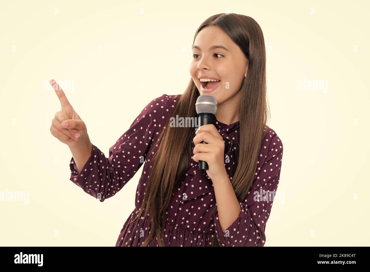 Hübsches kleines Mädchen, das mit dem Mikrofon singt. Porträt der emotionalen erstaunt aufgeregt Teenager-Mädchen. Stockfoto